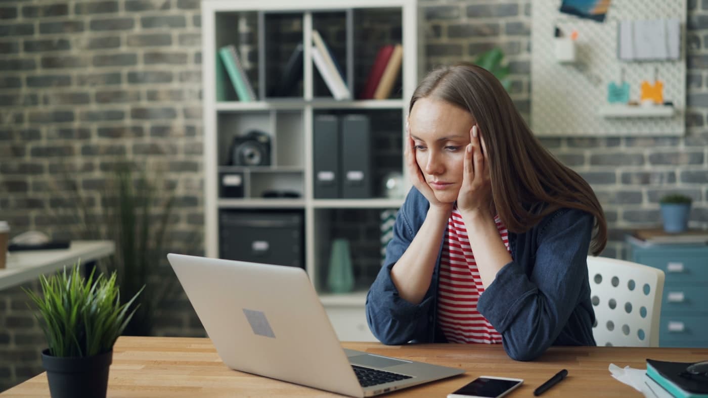 Custom closet company owner at a laptop, frustrated by an unpredictable flow of new jobs